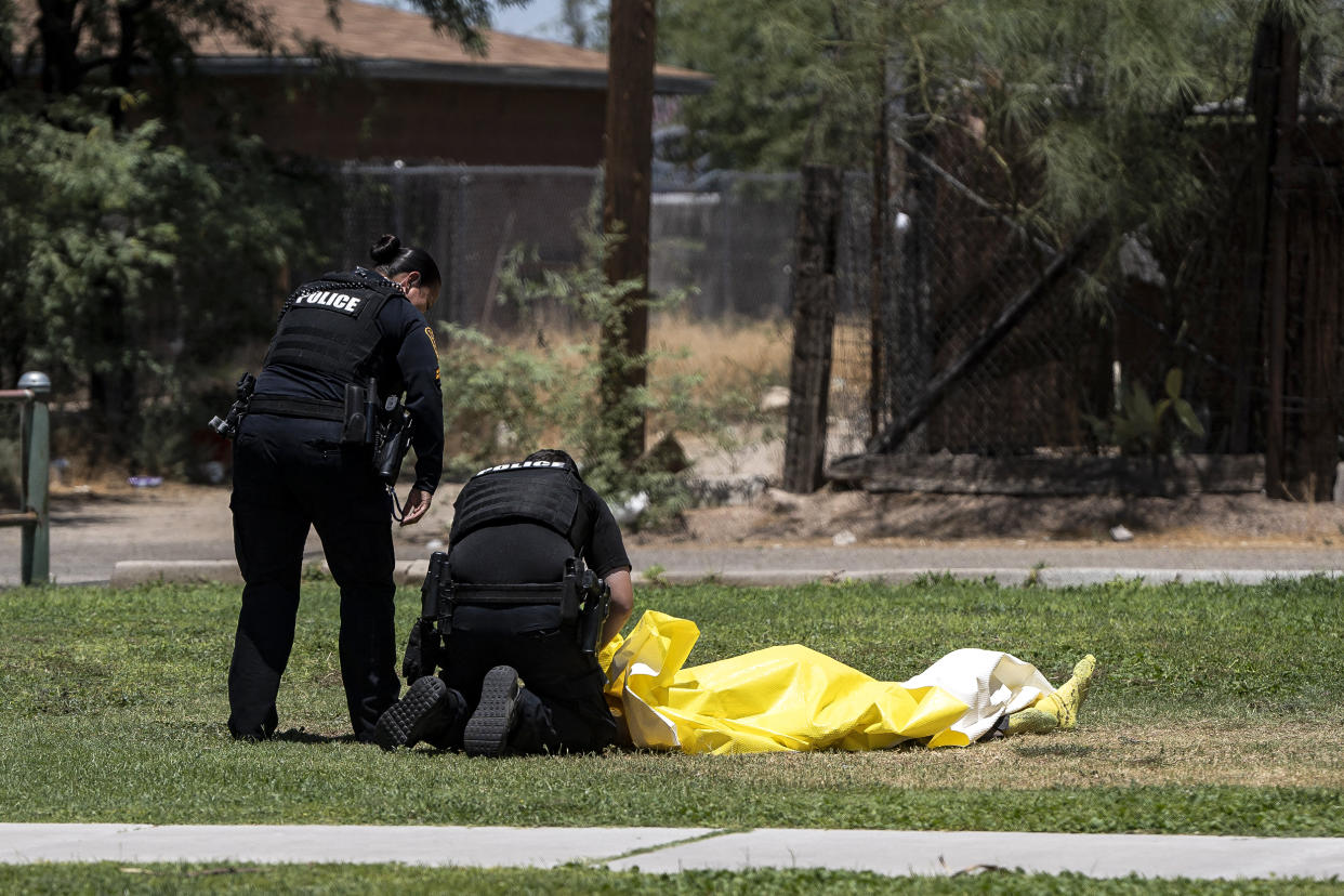 Image: Tucson police officers tend to an unhoused deceased person whose body temperature was 102 degrees Fahrenheit at the time of discovery at Estevan Park in Tucson (Rebecca Noble / AFP - Getty Images)