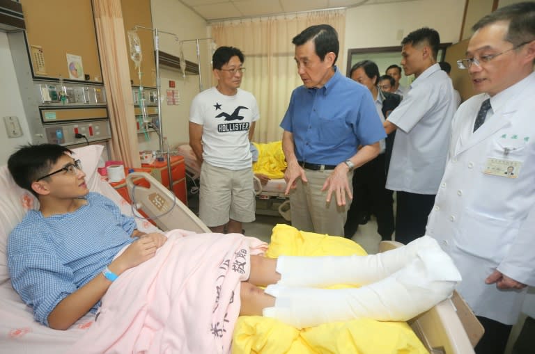 Taiwan's President Ma Ying-jeou (C) talks with a recuperating patient at a local hospital in Taipei on June 28, 2015, following a fireball at a water park that injured hundreds