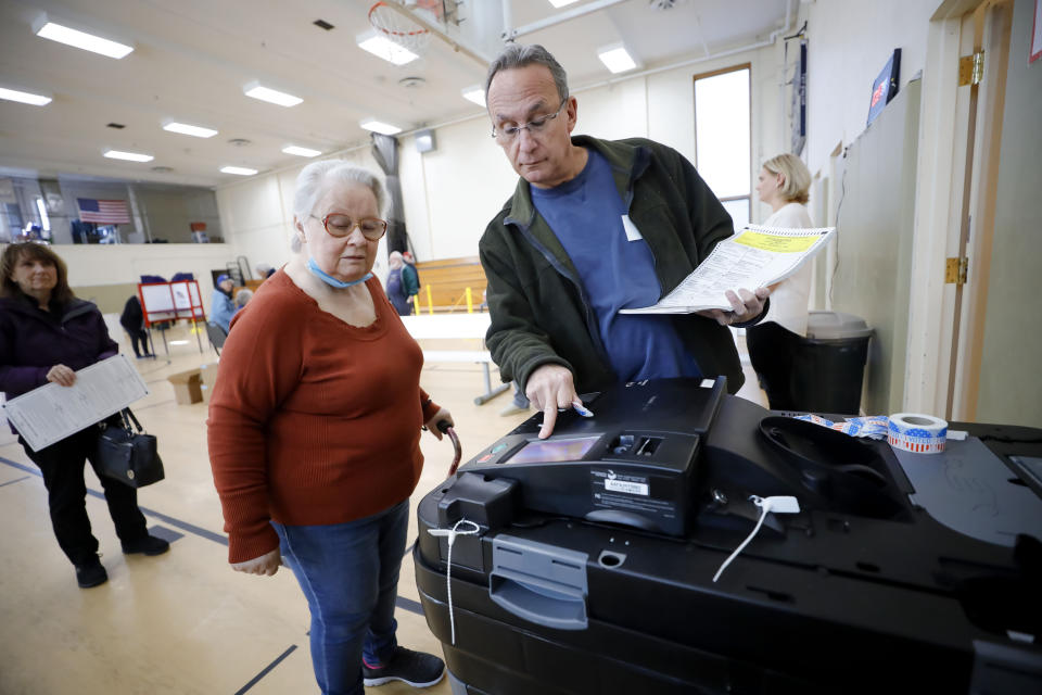 Ed Glickman assists Fran Furness as she casts her ballot on election day at Crossway Village in Lee, Mass. Tuesday, Nov. 8, 2022. (Stephanie Zollshan/The Berkshire Eagle via AP)