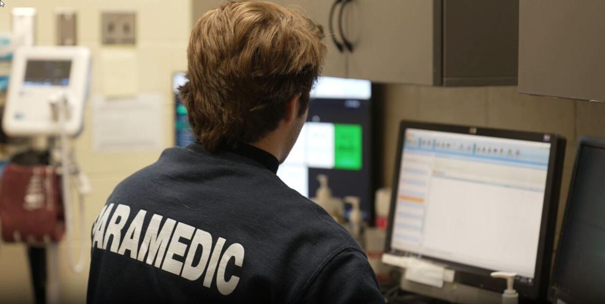 Steve Brown, a paramedic with the Regina Police Service, checks health data from one of the cells at the Regina police station. (Regina Police Service - image credit)