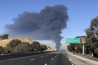 Interstate 80 is closed as a fire at an oil storage facility burns in the background Tuesday, Oct. 15, 2019, in Rodeo, Calif. A fire burning at NuStar Energy LP facility in Crockett, Calif., in the San Francisco Bay Area prompted a hazardous materials emergency that led authorities to order the residents of two communities, including Rodeo, to stay inside with all windows and doors closed. Contra Costa Fire Department spokesman Steve Hill said that an hour into battling the blaze, firefighters seemed to be making progress and were continuing to keep adjacent tanks cooled with water. (AP Photo/Ben Margot)