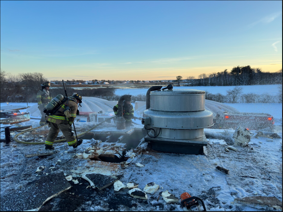 Firefighters tend to the roof of the Wells Sanitary District on Eldridge Road in Wells, Maine, after putting out a fire there in January of 2023.