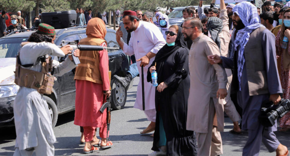 A member of the Taliban forces points his gun at protesters, as Afghan demonstrators shout slogans during an anti-Pakistan protest, near the Pakistan embassy in Kabul, Afghanistan. Source: Reuters 