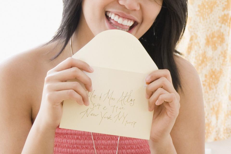 <p>Getty</p> A stock image of a woman licking an envelope