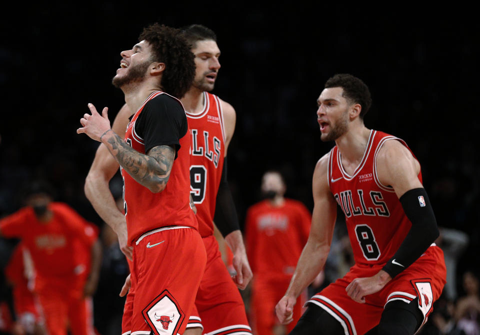 Chicago Bulls guard Lonzo Ball (2) celebrates with Nikola Vucevic (9) and Zach LaVine (8) after making a 3-point shot against the Brooklyn Nets during the second half of an NBA basketball game in New York, Saturday, Dec. 4, 2021. The Bulls won 111-107. (AP Photo/Noah K. Murray)