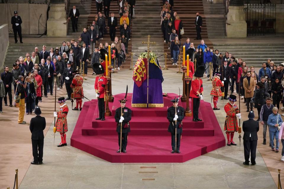 The final members of the public pay their respects at the coffin of Queen Elizabeth II, draped in the Royal Standard with the Imperial State Crown and the Sovereign’s orb and sceptre, lying in state on the catafalque in Westminster Hall at the Palace of Westminster (AP)