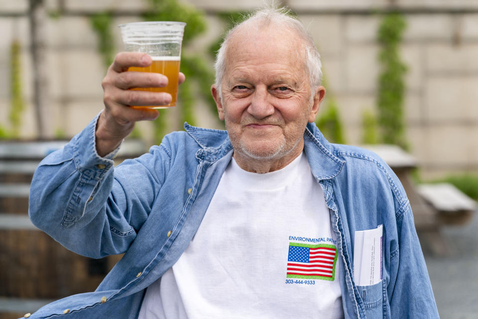 George Ripley, 72, of Washington, holds up his free beer after receiving the J & J COVID-19 vaccine shot, Thursday, May 6, 2021, at The REACH at the Kennedy Center in Washington. "I'm relieved to have one and be done with it," says Ripley, "that's it. I'm happy to be out here." People who received a vaccination at the event had the option to have a free beer. (AP Photo/Jacquelyn Martin)