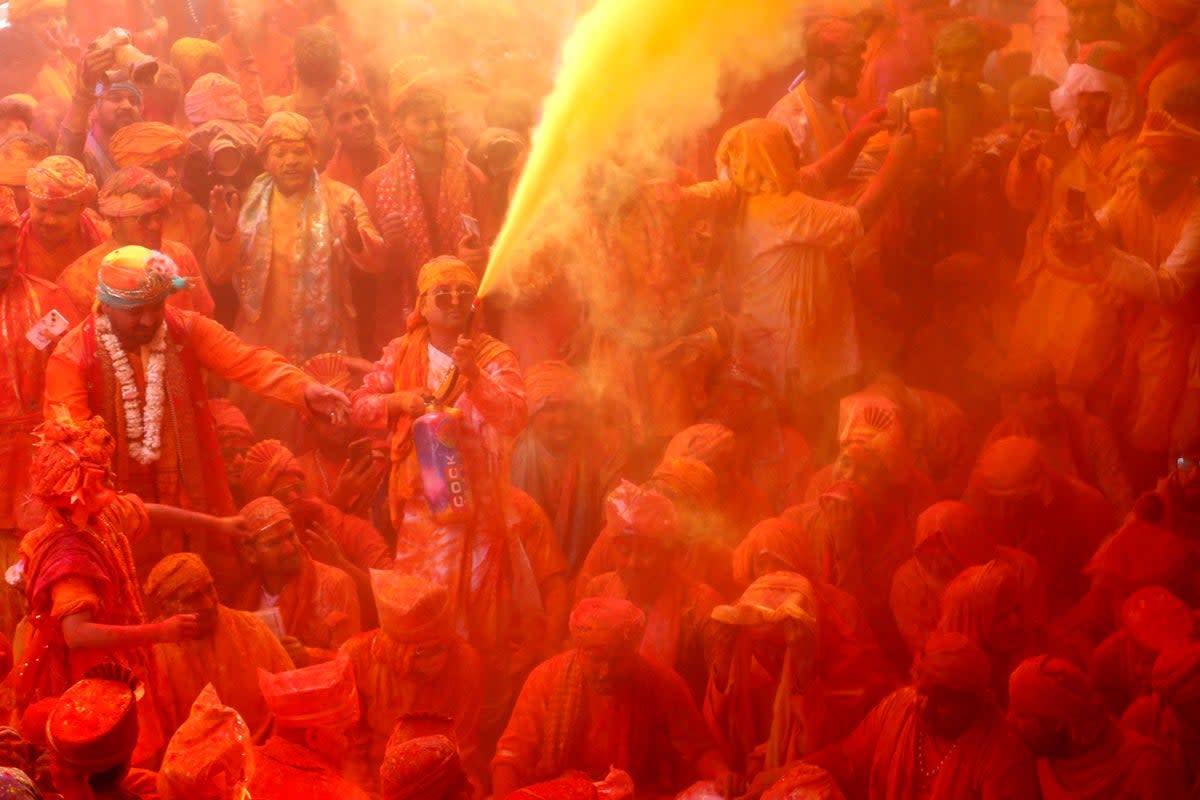 Devotees smear themselves with colours as they celebrate the Hindu spring festival of Holi at Shreeji temple in Barsana, Mathura (AFP via Getty Images)