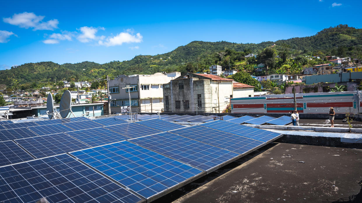 Solar panels on a rooftop in Adjuntas, Puerto Rico, contribute to a new community-owned microgrid project.