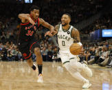 Milwaukee Bucks' Damian Lillard (0) drives against Toronto Raptors' Ochai Agbaji during an NBA basketball game Friday, April 5, 2024, in Milwaukee. (AP Photo/Jeffrey Phelps)