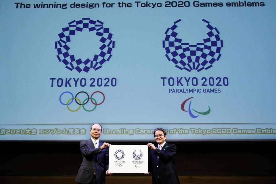 FILE - In this April 25, 2016, file photo, Tokyo 2020 Emblems Selection Committee Chairperson Ryohei Miyata, right, and its member and Japanese baseball great Sadaharu Oh hold new official logos of the 2020 Tokyo Olympics, left, and the 2020 Tokyo Paralympic Games during the unveiling ceremony in Tokyo. (AP Photo/Shizuo Kambayashi, File)