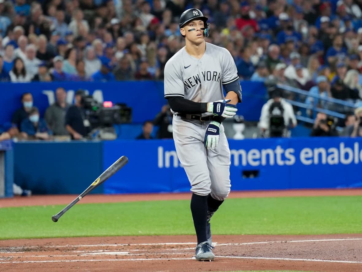 New York Yankees right fielder Aaron Judge tosses his bat as he gets walked by Toronto Blue Jays starting pitcher Kevin Gausman during third inning American League baseball action in Toronto Monday. Judge remains on the cusp of tying the single-season AL home run record. (Nathan Denette/The Associated Press - image credit)