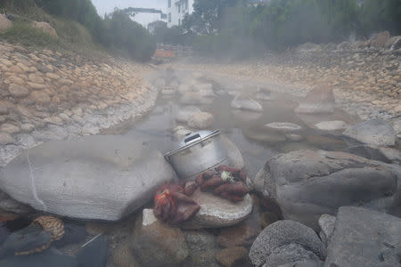 Purple yams and a pot containing rice noodles placed by villagers are seen at a hot spring attraction in Rucheng county, Hunan province, China December 2, 2018. Picture taken December 2, 2018. REUTERS/Shu Zhang