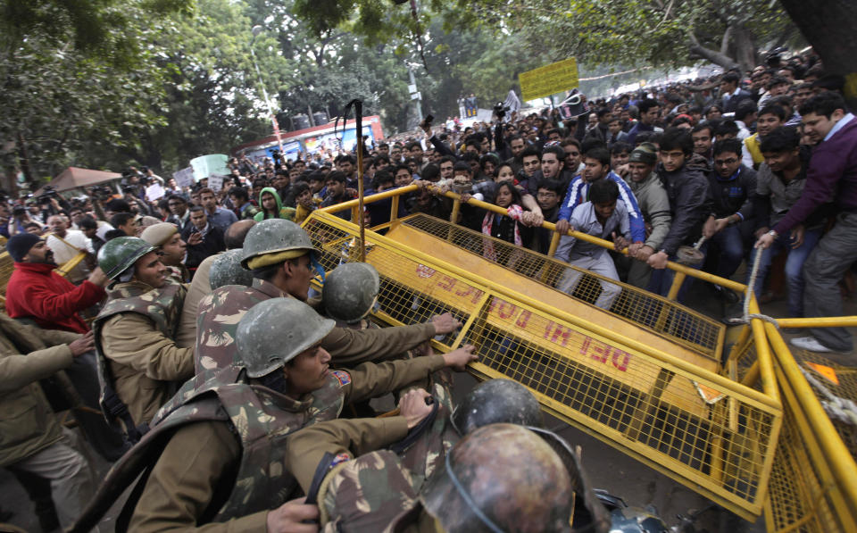 Members of the student wing of Indias main opposition Bharatiya Janata Party try to break through a police cordon during a protest after the death of a young woman who was recently gang-raped in a moving bus in New Delhi, India, Sunday, Dec. 30, 2012. (AP Photo/Altaf Qadri)