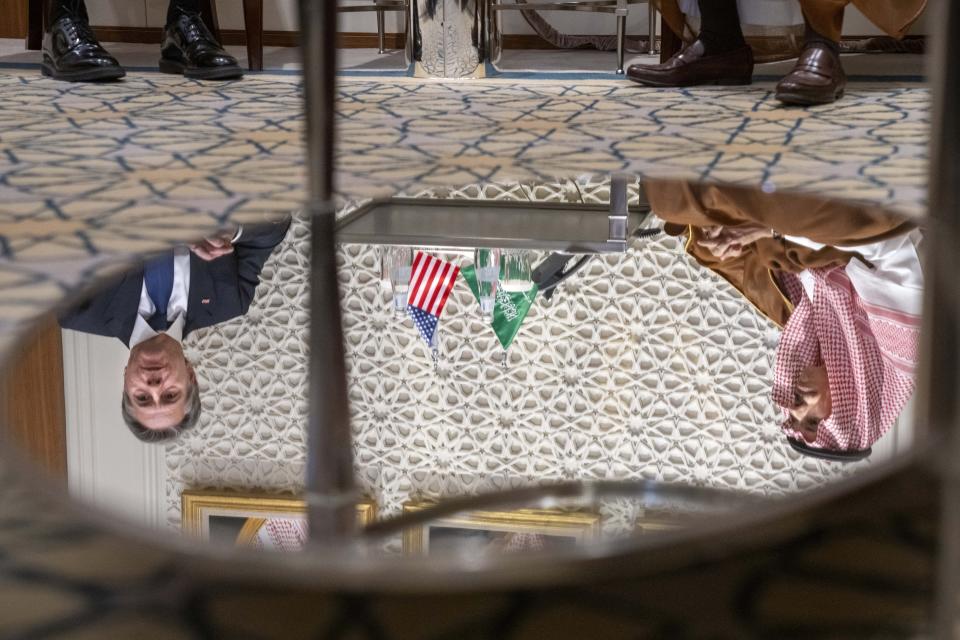 Reflected in a mirrored table, U.S. Secretary of State Antony Blinken, left, meets with Saudi Foreign Minister Prince Faisal bin Farhan, at the Ministry of Foreign Affairs in Riyadh, Saudi Arabia, Saturday Oct. 14, 2023. (AP Photo/Jacquelyn Martin, Pool)
