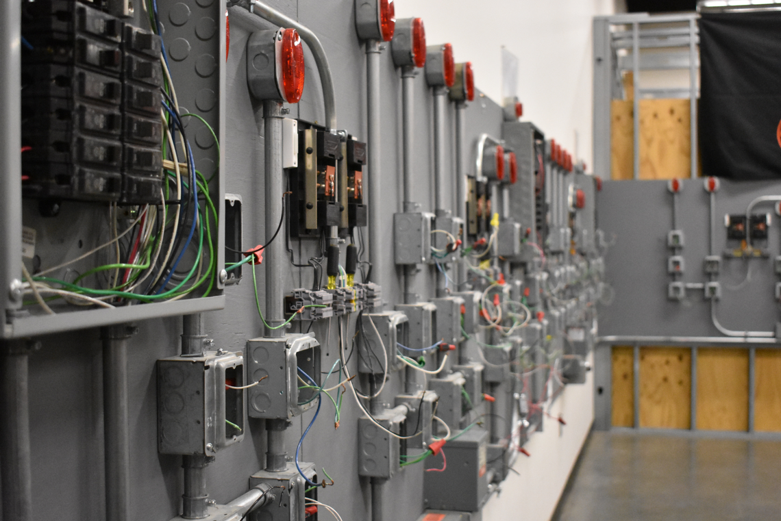 A wall of simple electrical panels used for small appliances like light switches and doorbells is shown at the Electrical Joint Apprenticeship and Training Center in Kansas City on Wednesday, Nov. 16, 2022. The voltage of the panels is artificially lowered to just 12 volts for training purposes.