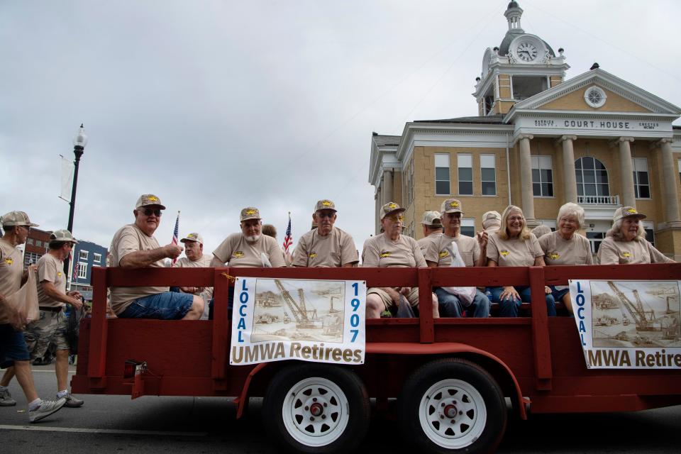 The United Mine Workers of America Local 1907 cruise past the Warrick County Court House during the 136th Annual Labor Day Association Parade in Boonville, Ind.