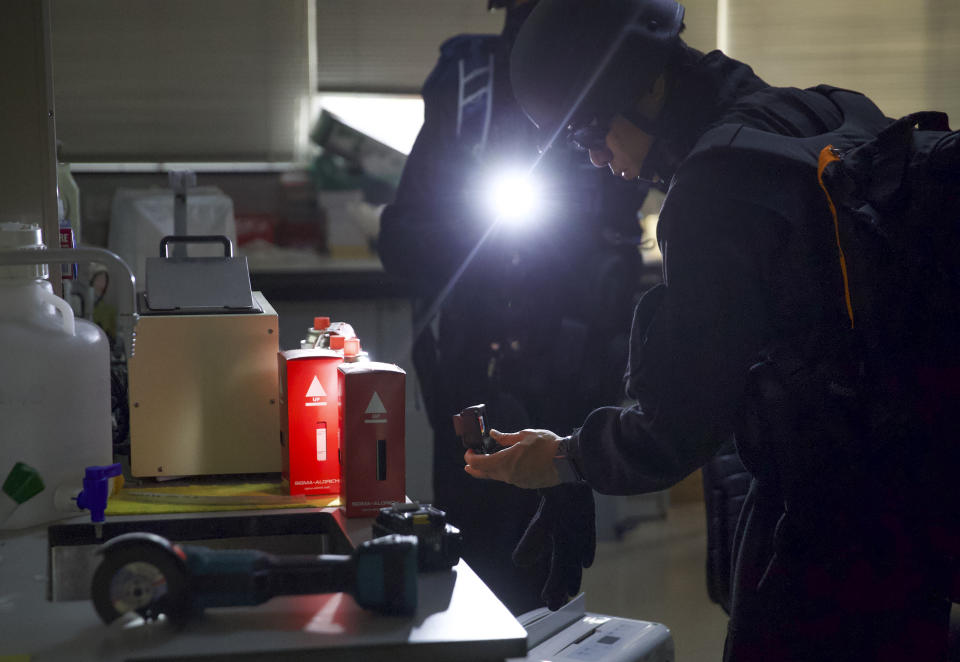 Policemen from Explosive Ordnance Disposal (EOD) unit search for dangerous materials at bio laboratory inside the Hong Kong Polytechnic University campus in Hong Kong, Thursday, Nov. 28, 2019. Police safety teams Thursday began clearing a university that was a flashpoint for clashes with protesters, and an officer said any holdouts still hiding inside would not be immediately arrested. (AP Photo/Ng Han Guan)