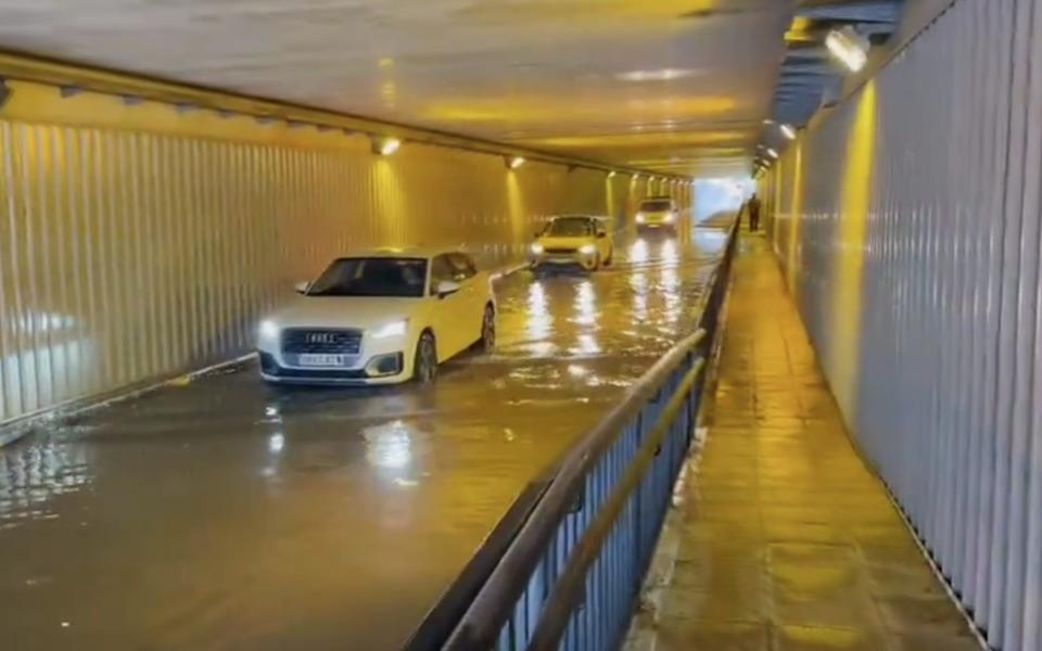 Cars drive through a flooded tunnel in Majorca