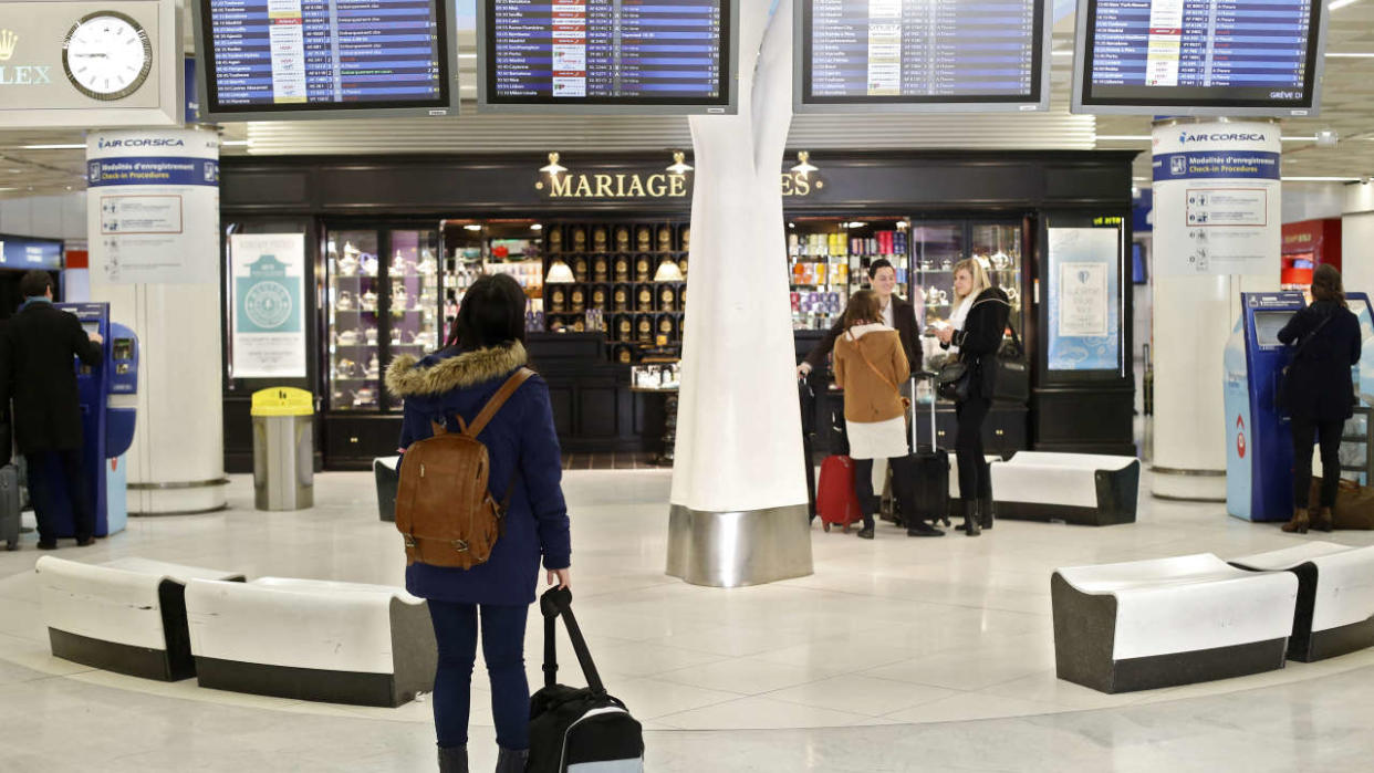 (FILES) In this file photo taken on April 08, 2015, a passenger looks at departures boards, on April 8, 2015 at Orly airport, outside Paris, as hundreds of flights to and from France were expected to be cancelled today as air traffic controllers launched a two-day strike over working conditions. - The Directorate General of Civil Aviation (DGAC) asked airlines on February 5, 2023 to preventively cancel one flight out of five at Orly airport in Paris on February 7, 2023, due to a strike of air traffic controllers for the third day of mobilization against the pension reform. (Photo by Thomas SAMSON / AFP)