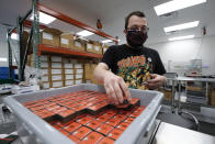 Bill Mathis packages THC products in Hazel Park, Mich., Thursday, April 29, 2021. A former teacher, Mathis has taken a new job in Michigan’s newly legalized cannabis industry. The pay is better, the hours more regular, the stress less, he says. No longer does he worry that he’ll catch COVID-19. (AP Photo/Paul Sancya)