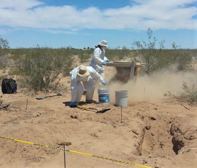 Chihuahua state police investigators sift for clues next to a clandestine desert grave found at Ejido 6 de Enero near the border village of Palomas.