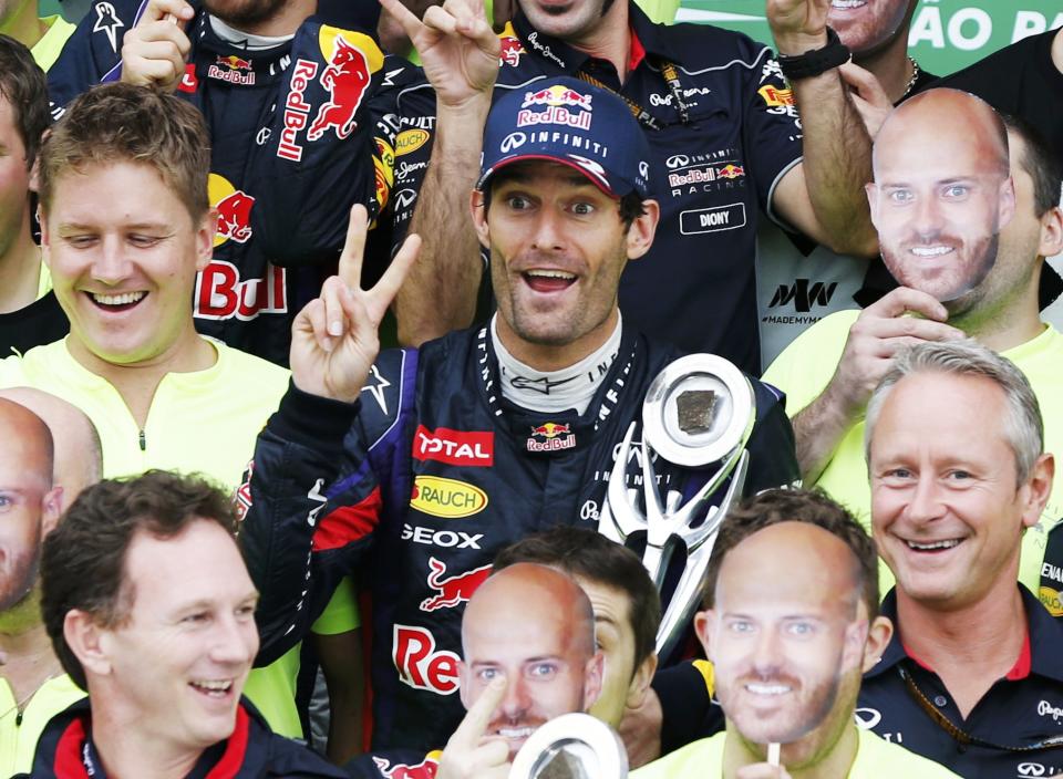 Mark Webber of Australia and the members of the Red Bull team joke as they pose for pictures after the Brazilian F1 Grand Prix at the Interlagos circuit in Sao