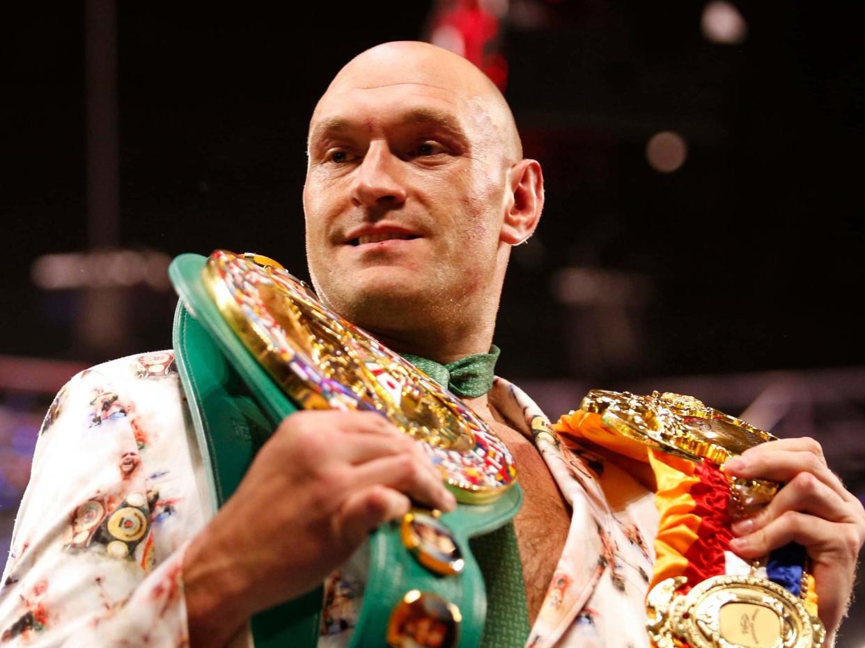 Tyson Fury poses with his belts: Reuters