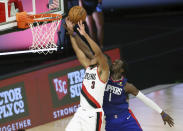 Los Angeles Clippers guard Reggie Jackson (1) fouls Portland Trail Blazers guard CJ McCollum (3) during the first half of an NBA basketball Saturday, Aug. 8, 2020, in Lake Buena Vista, Fla. (Kim Klement/Pool Photo via AP)