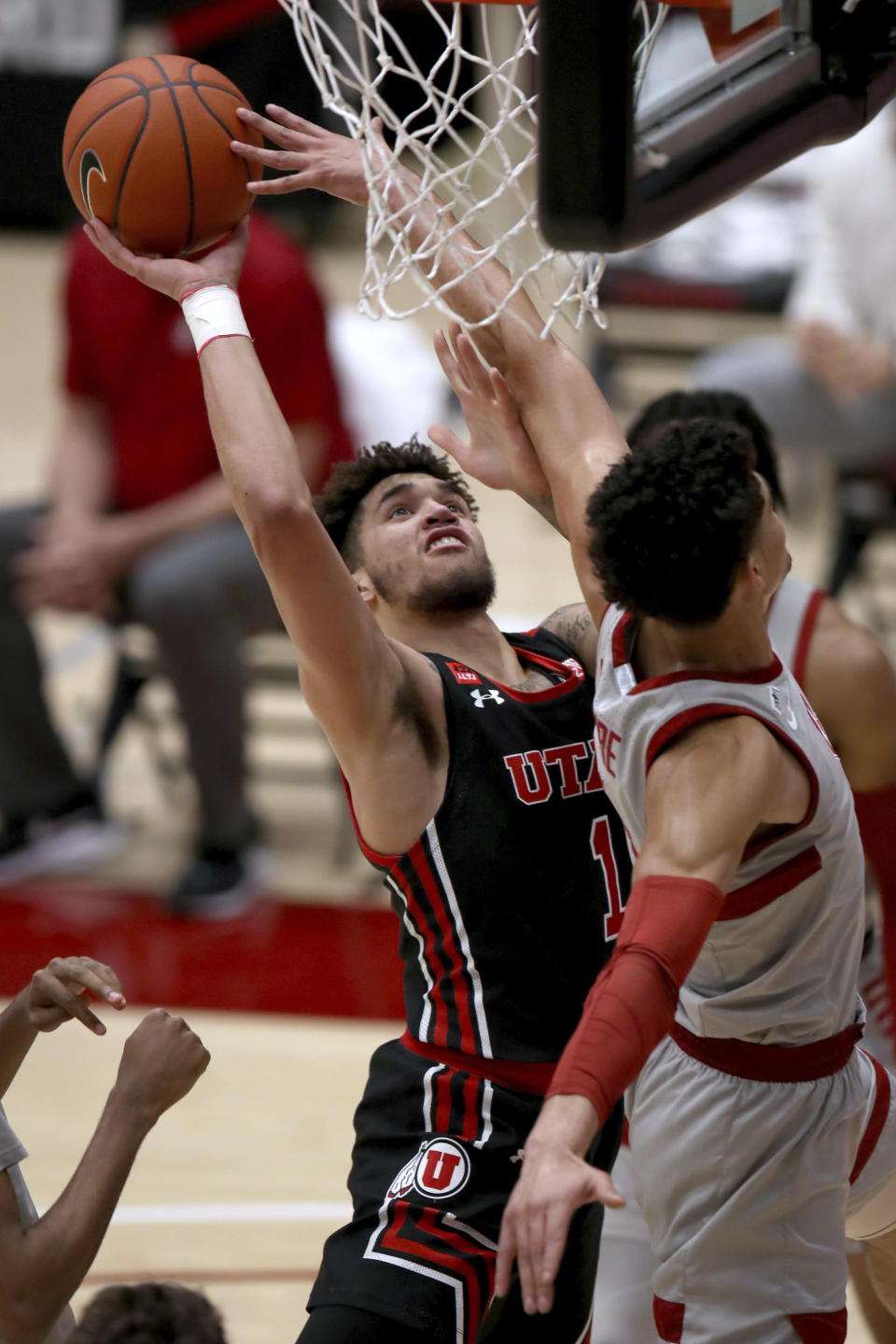 Utah forward Timmy Allen (1) scores against Stanford forward Jaiden Delaire during the first half of an NCAA college basketball game Saturday, Feb. 13, 2021, in Stanford, Calif. (AP Photo/Scot Tucker)