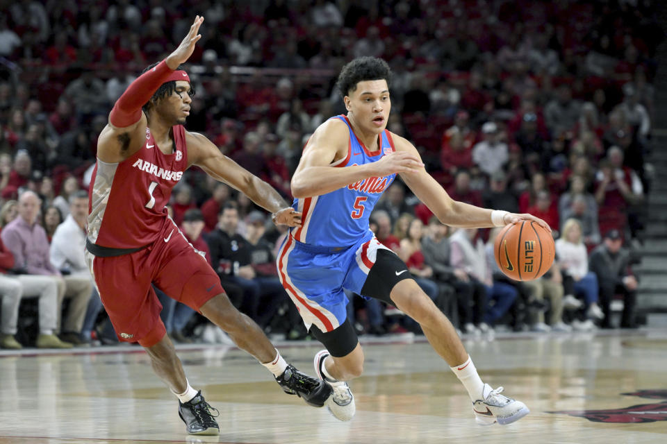 Mississippi guard James White (5) drives past Arkansas guard Ricky Council IV (1) during the first half of an NCAA college basketball game Saturday, Jan. 21, 2023, in Fayetteville, Ark. (AP Photo/Michael Woods)