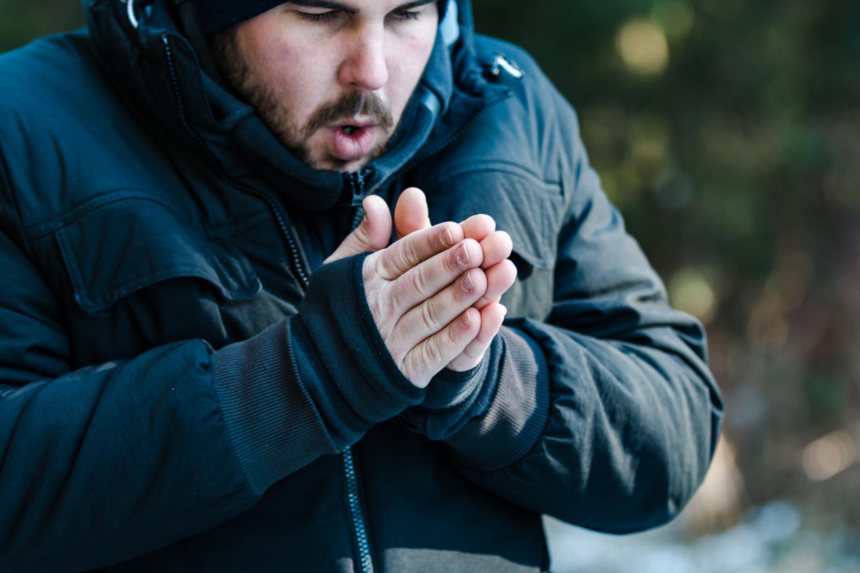 This rechargeable hand warmer is winning over Amazon shoppers. Man warming his hands with his breath