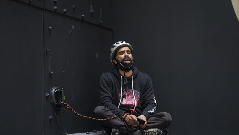 A pro-Palestinian activist sits atop a sculpture by Alexander Calder after hanging a Palestinian flag over the structure in the Hart Senate Office Building on Capitol Hill in Washington on Monday, Dec. 11, 2023. Congress is on hold in approving critical new aid for Ukraine and Israel this week.