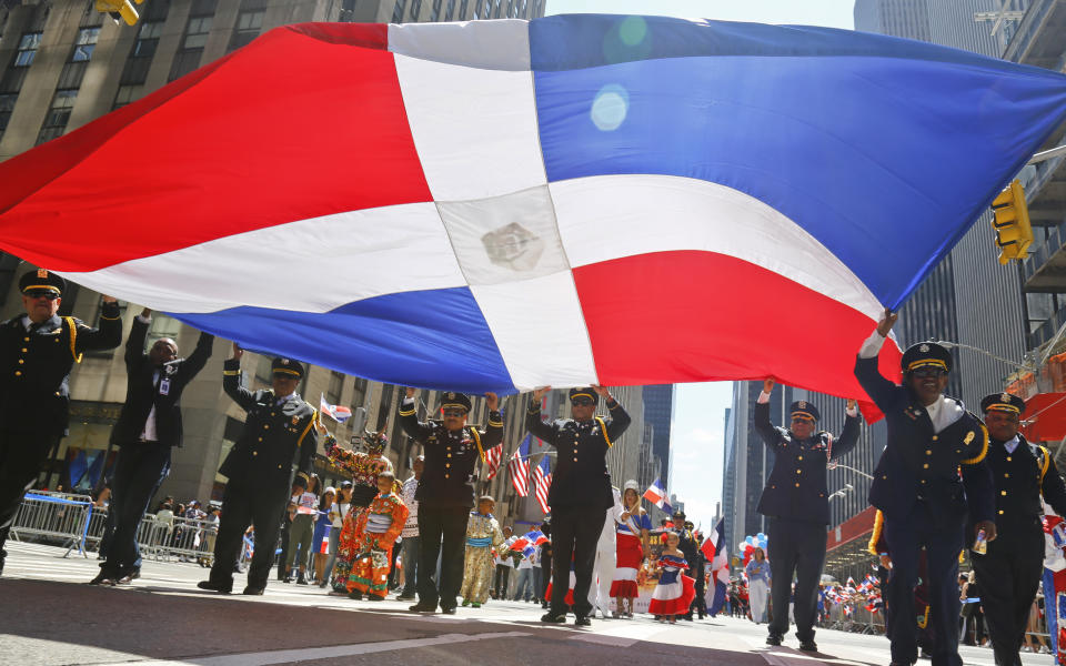 FILE -A giant Dominican flag is hoisted by marchers during the Dominican Day Parade," Sunday Aug. 13, 2017, in New York. A new report released Monday, May 2, 2022 by Pew Research Center says about 6 million adults in the United States identify as Afro Latino, a distinction with deep roots in colonial Latin America. That’s about 2% of the adult U.S. population and 12% of the adult Latino population in the U.S. Many Hispanic people identify themselves based on their ancestral countries of origin, their Indigenous roots or racial background. (AP Photo/Bebeto Matthews, File)