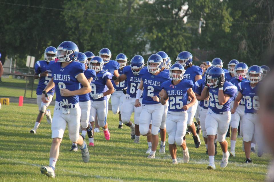 The Perry football team runs onto the field during the Fall Kickoff on Friday, Aug. 18, 2023.