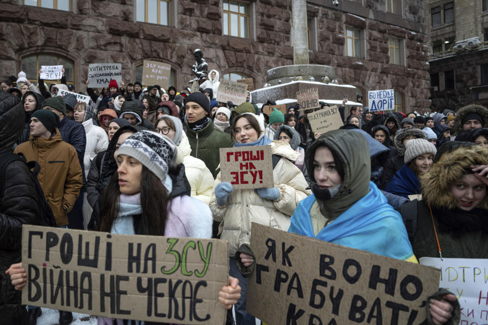 Activists hold signs "Money for the Ukrainian Armed Forces" during a protest in front of city council of Kyiv, Ukraine, Thursday, Dec. 14, 2023. 500 representatives of the territorial community of Kyiv and the "Money for the Ukrainian Armed Forces" initiative group came to the protest to support the Security and Defense Forces of Ukraine from the budget of Kyiv, which is filled at the expense of taxpayers, subventions and other revenues. (AP Photo/Evgeniy Maloletka)