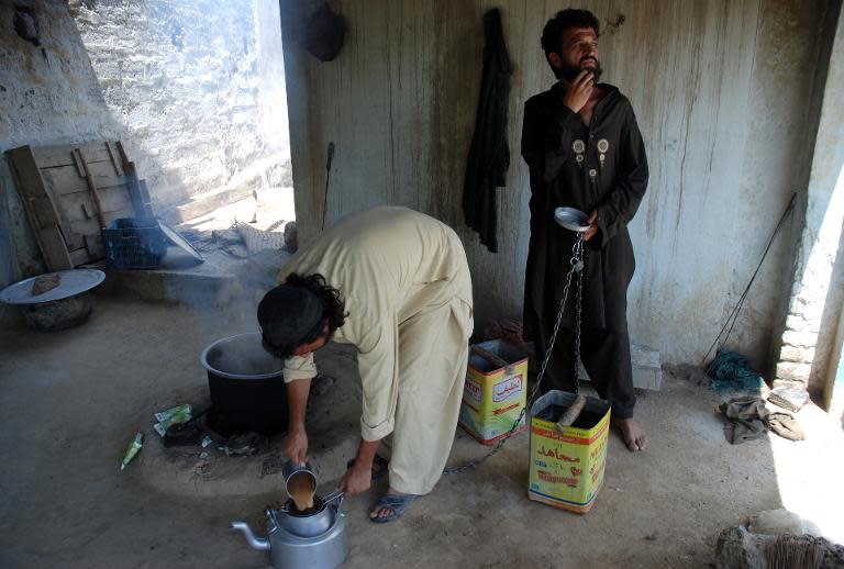 Chained Pakistani drug addicts make tea at a brutal addiction centre run by a local cleric in Haripur on July 19, 2014