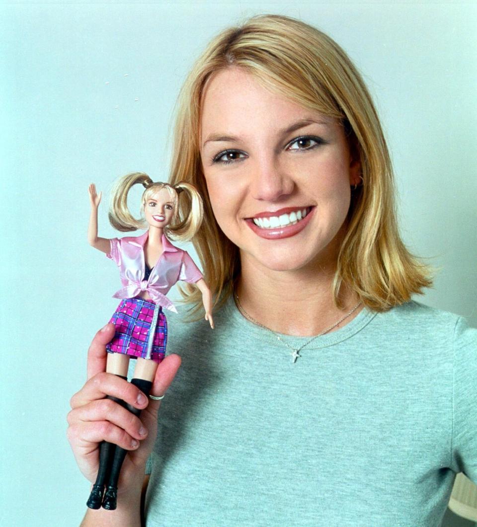 Spears posing with her Barbie doll in 1999