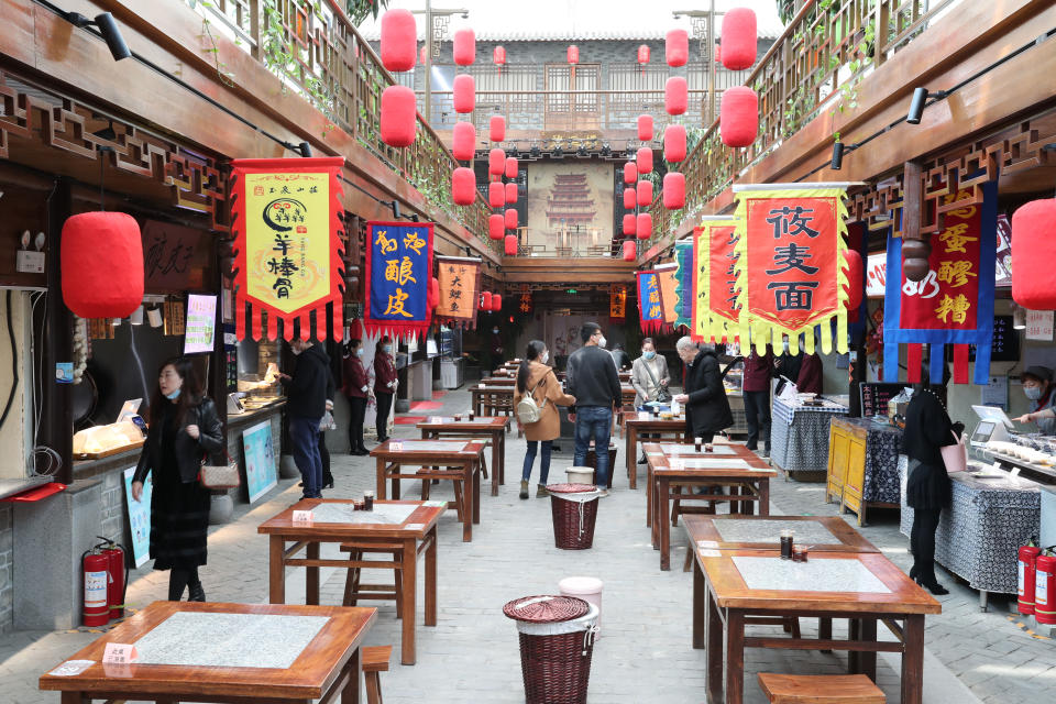 Clientes observan las tiendas y restaurantes de una zona comercial de Lanzhou, en la provincia de Gansu. (Foto: Du Zheyu / Xinhua / Getty Images).