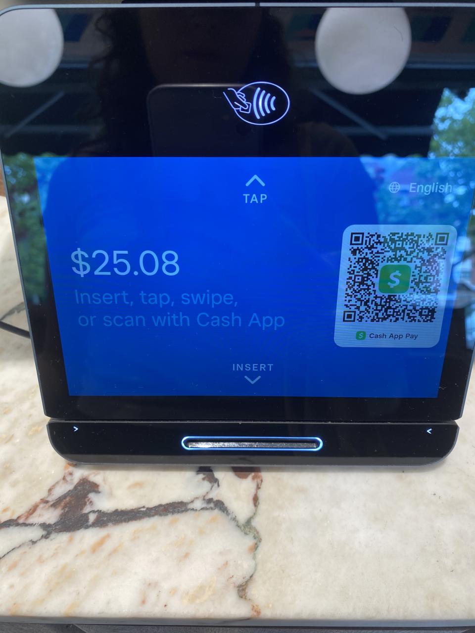 A payment terminal with a screen showing a total of $25.08 and options to insert, tap, swipe, or scan with Cash App for payment