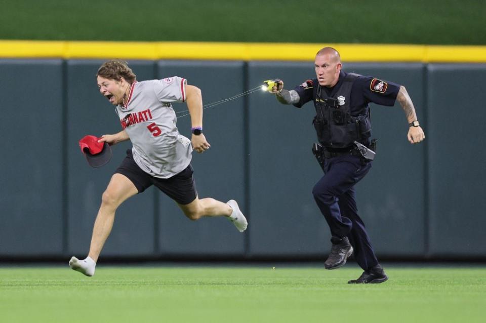 CINCINNATI, OHIO - JUNE 11:  An unidentified fan is tased by a police officer as he runs on the field before the ninth inning of the Cincinnati Reds against Cleveland Guardians at Great American Ball Park on June 11, 2024 in Cincinnati, Ohio. (Photo by Andy Lyons/Getty Images)