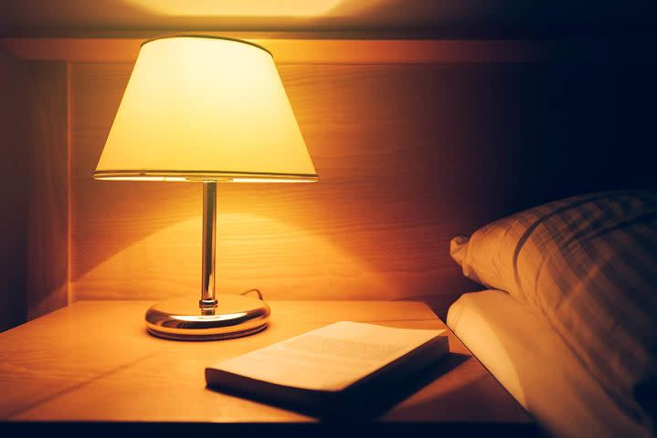 The Harth Sleep-Shift Light Bulb running next to a bed.