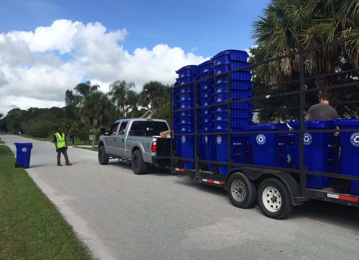 Jerard Ross of Vero Beach was part of a crew on Friday, Oct. 2, 2015, distributing Indian River County recycling bins in the 2700 block of First Street, Vero Beach.