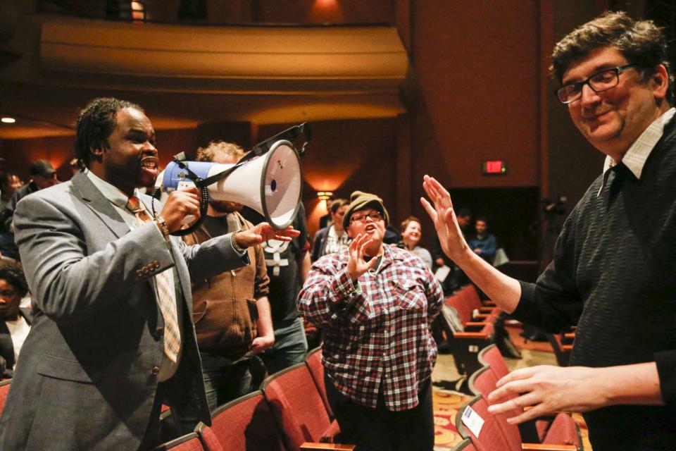 Protesters, including Vauhxx Booker, holding megaphone, who were upset with the city’s purchase of a $225,000 armored vehicle for the Bloomington Police Department, argue with city councilman Steve Volan, right, after interrupting the mayor’s State of the City speech Feb. 15, 2018, at the Buskirk-Chumley Theater in Bloomington.