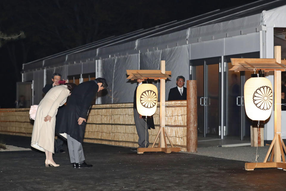 Japanese Prime Minister Shinzo Abe and his wife Akie Abe bow in front of the main gate of Daijo hall to attend a ceremony for Emperor Naruhito in Tokyo Thursday, Nov. 14, 2019. Emperor Naruhito performed a secretive and controversial ritual Daijosai Thursday, a once-in-a-reign event to give thanks for good harvests, pray for the peace and safety of the nation and play host to his family’s ancestral gods. (Hiroko Harima/Kyodo News via AP)