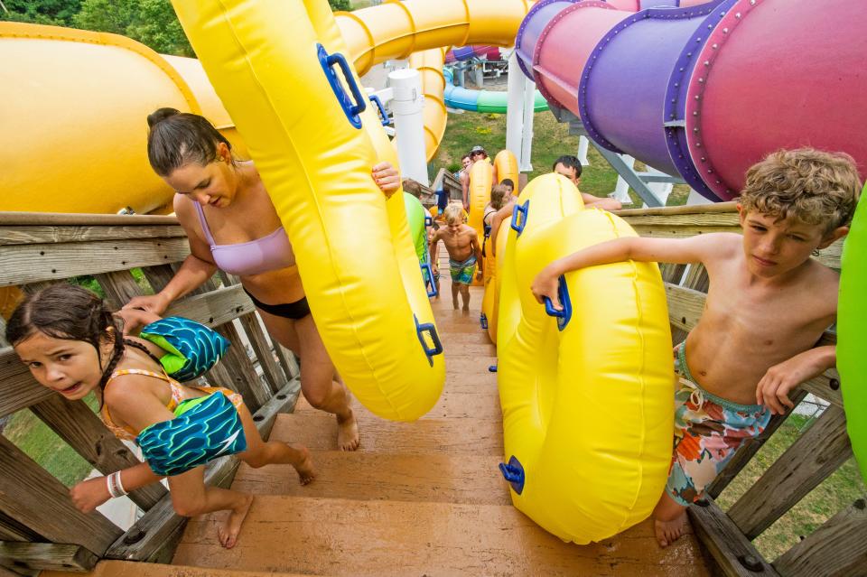 Visitors form a long line, on July 8, 2022, to slide down the Bermuda Triangle on an 80 degree summer day at the Waldameer Park and Water World in Erie. The Bermuda Triangle has three adjacent water slides.