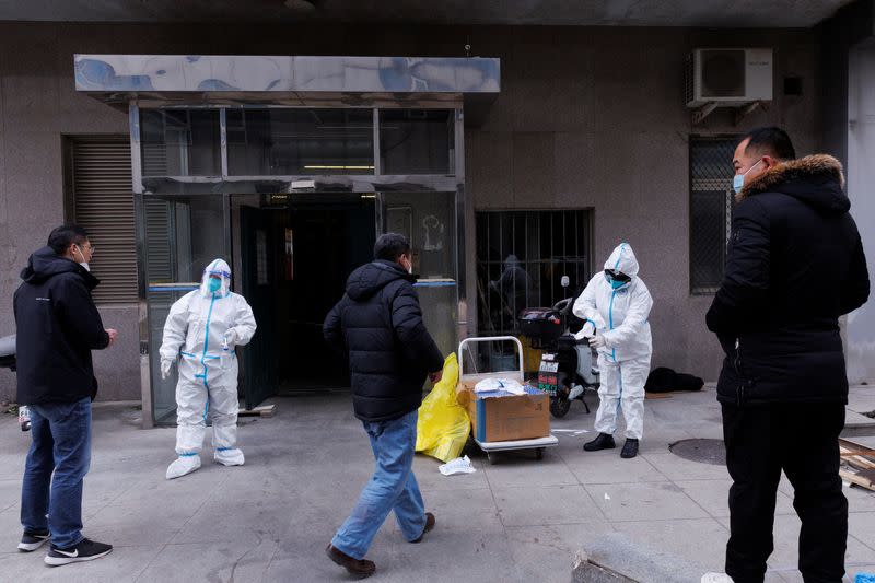 Pandemic prevention workers in protective suits get ready to enter an apartment building that went into lockdown as coronavirus disease (COVID-19) outbreaks continue in Beijing