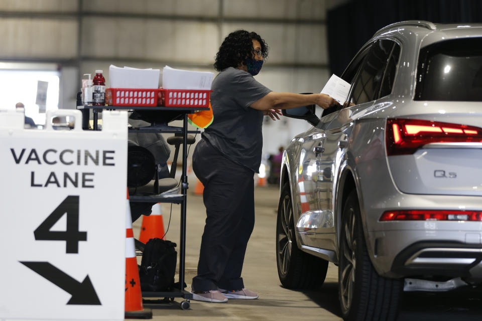 Judy Shavers administers a coronavirus vaccine at the drive-thru clinic Thursday, June 10, 2021, in Columbus, Ohio. The U.S. is confronted with an ever-growing surplus of COVID-19 vaccines, looming expiration dates and stubbornly lagging demand at a time when the developing world is clamoring for doses to stem a rise in infections. (AP Photo/Jay LaPrete)