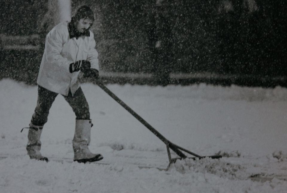 A worker pushes snow from the field at Mile High Stadium during the "Monday Night Football" between the Green Bay Packers and Denver Broncos on Oct. 15, 1984. An autumn storm dumped 10 inches of snow on the Denver area making the game into one of the more memorable moments for "Monday Night Football."