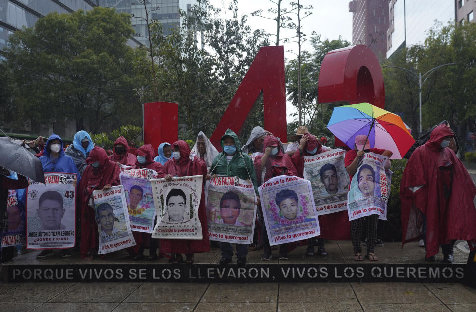 Friends and relatives seeking justice for the missing 43 Ayotzinapa students gather round a monument dedicated to the students during a demonstration in Mexico City, Friday, Aug. 26, 2022. Six of the 43 college students "disappeared" in 2014 were allegedly kept alive in a warehouse for days then turned over to the local army commander who ordered them killed, the Mexican government official leading a Truth Commission said Friday. (AP Photo/Marco Ugarte)